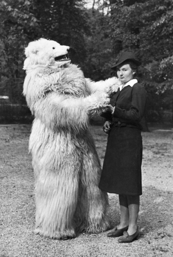 Unhappy woman dances with person in a polar bear costume.  German, ca. 1935